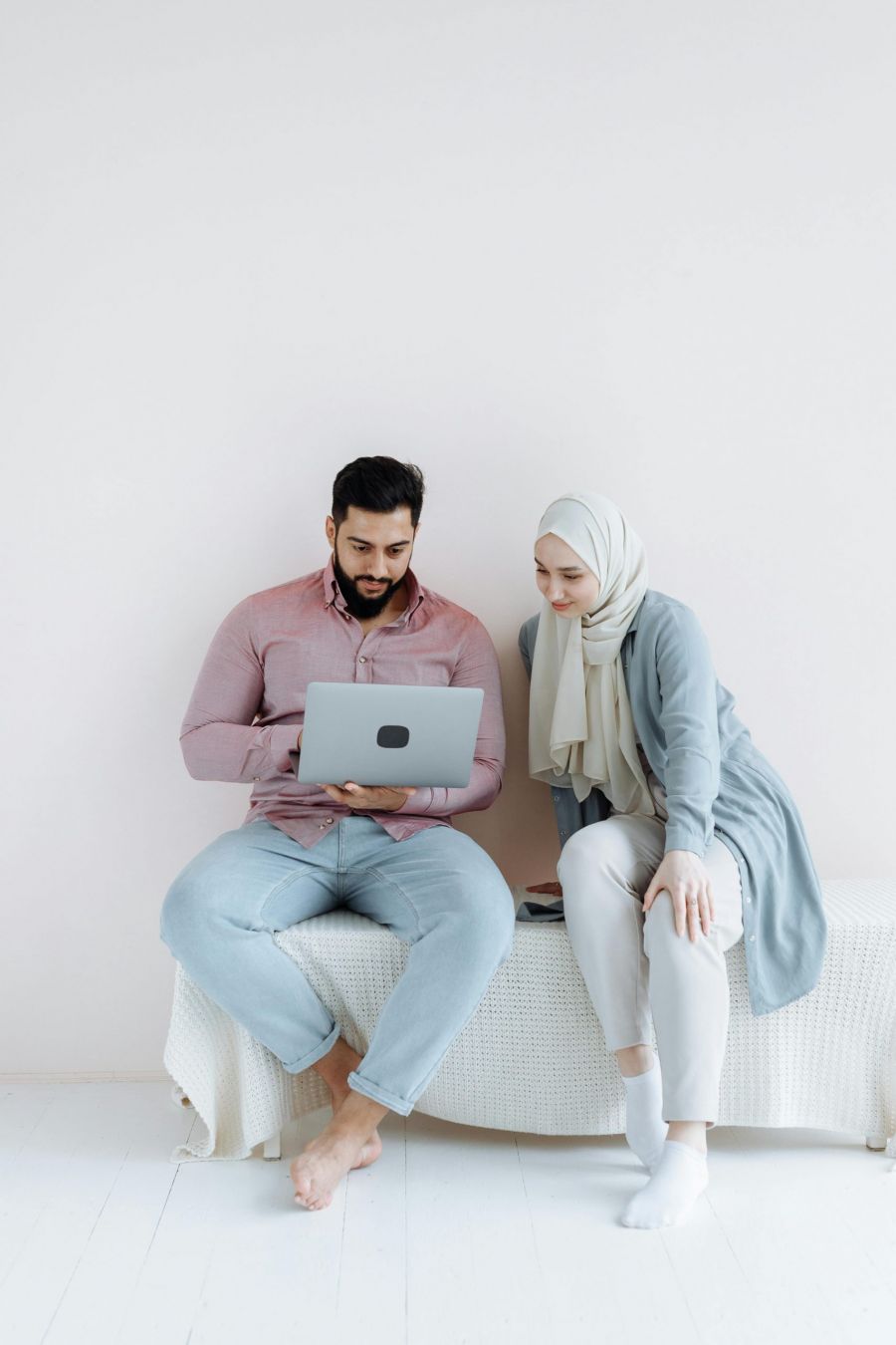 Couple planning how to get married in Bahrain fast using laptop