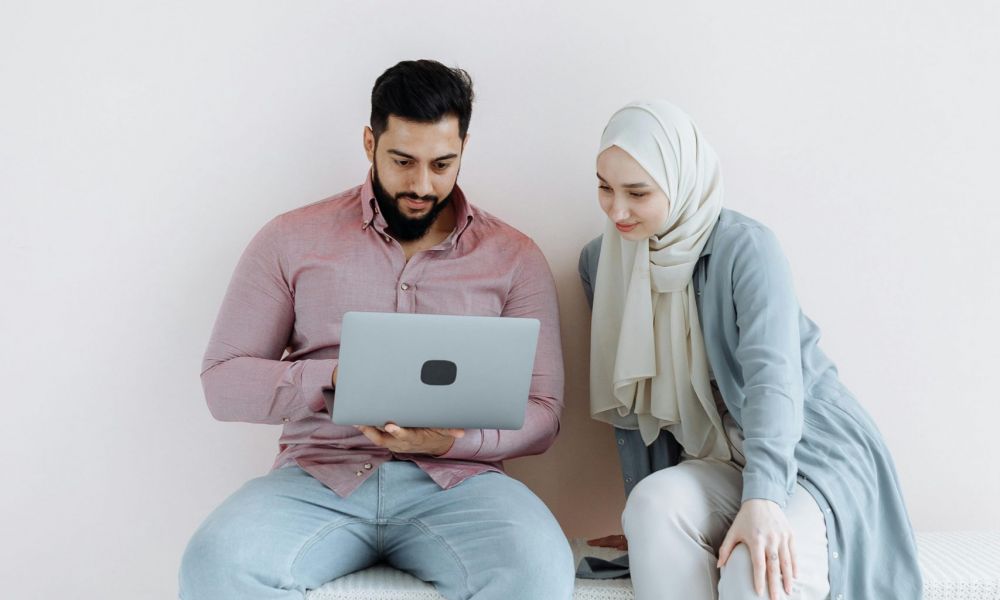 Couple planning how to get married in Bahrain fast using laptop