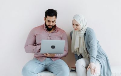 Couple planning how to get married in Bahrain fast using laptop